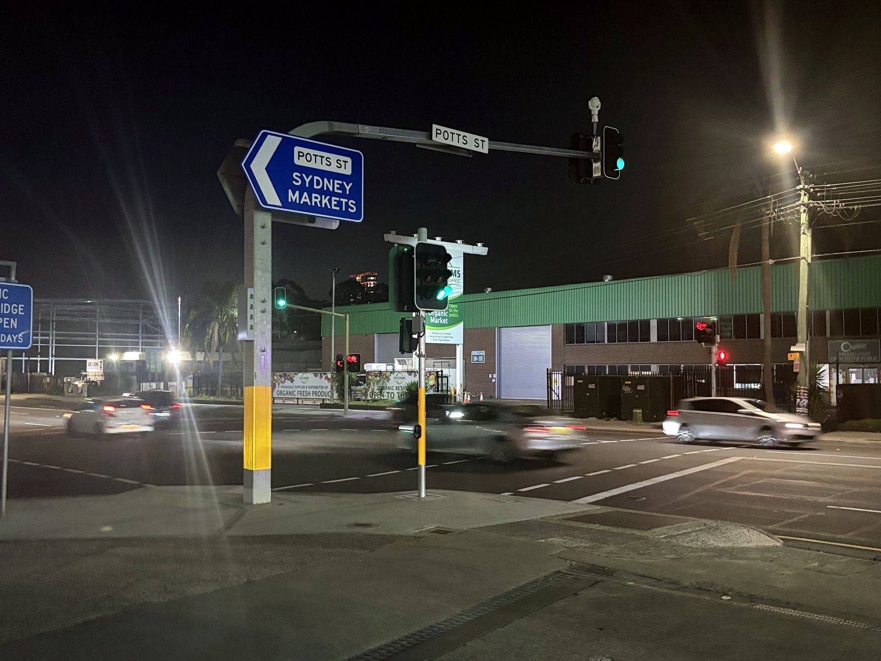 Night view of the Potts Street signals at Parramatta Road, Homebush, the Sydney Markets sign overhead