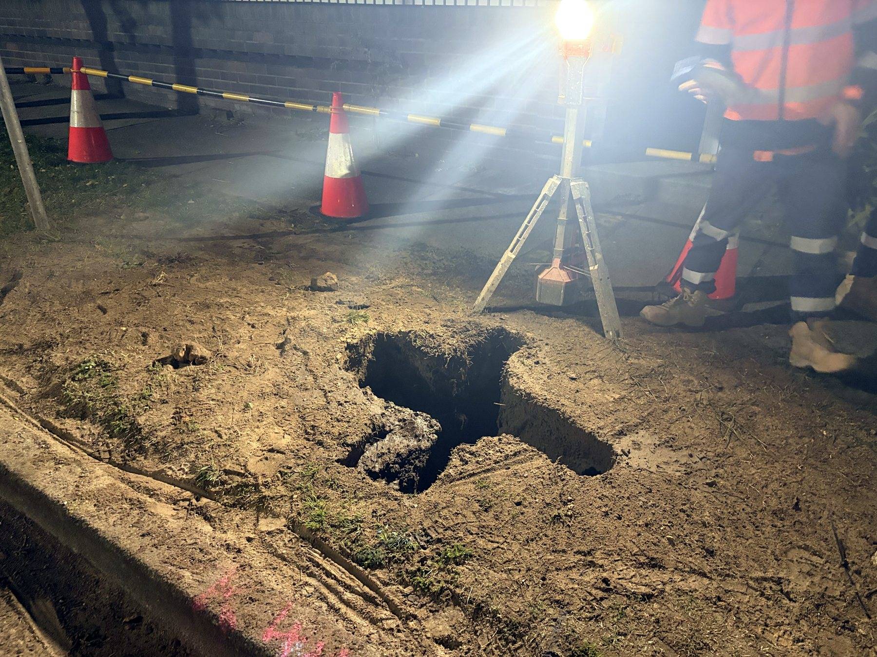Signal post footing excavation under work lights at a closed Randwick intersection at night