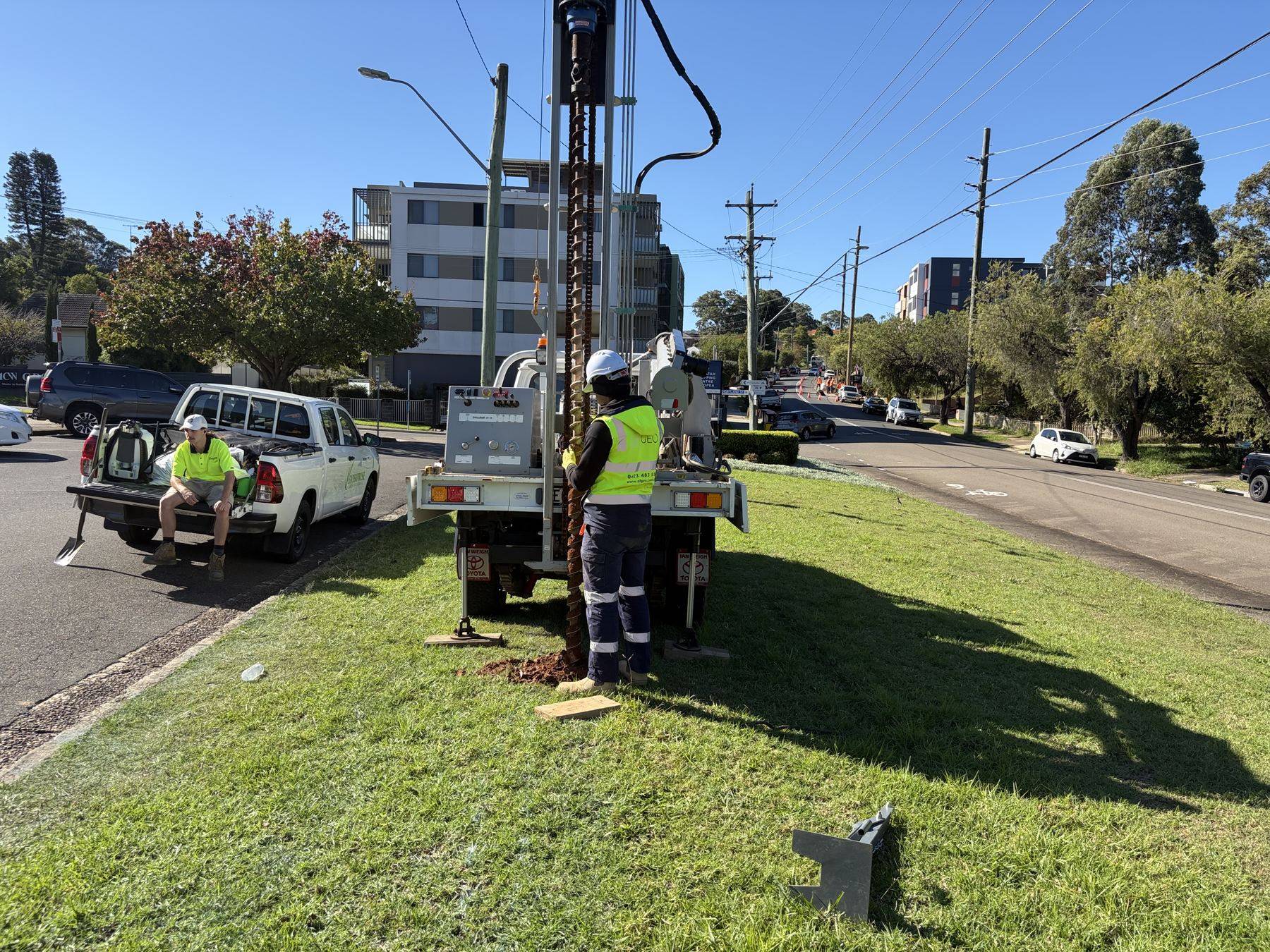 SFGEO 4WD rig drilling from the grass verge of a residential street in Telopea, footpath and traffic lane still open