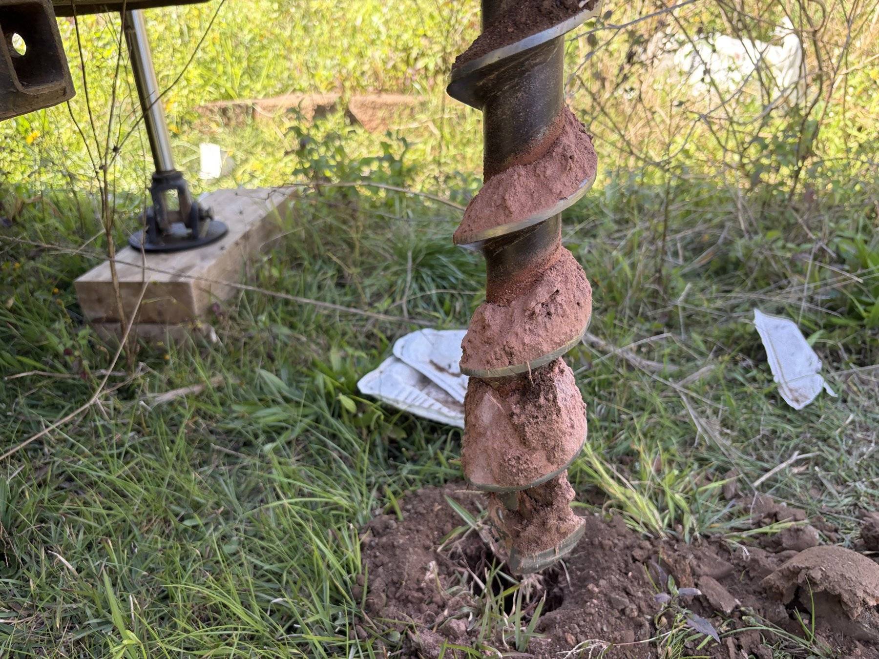 Clay-loaded auger flight advancing a borehole
