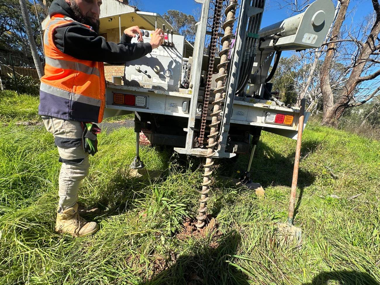 SFGEO 4WD-mounted drill rig with mast raised on a Sydney reserve
