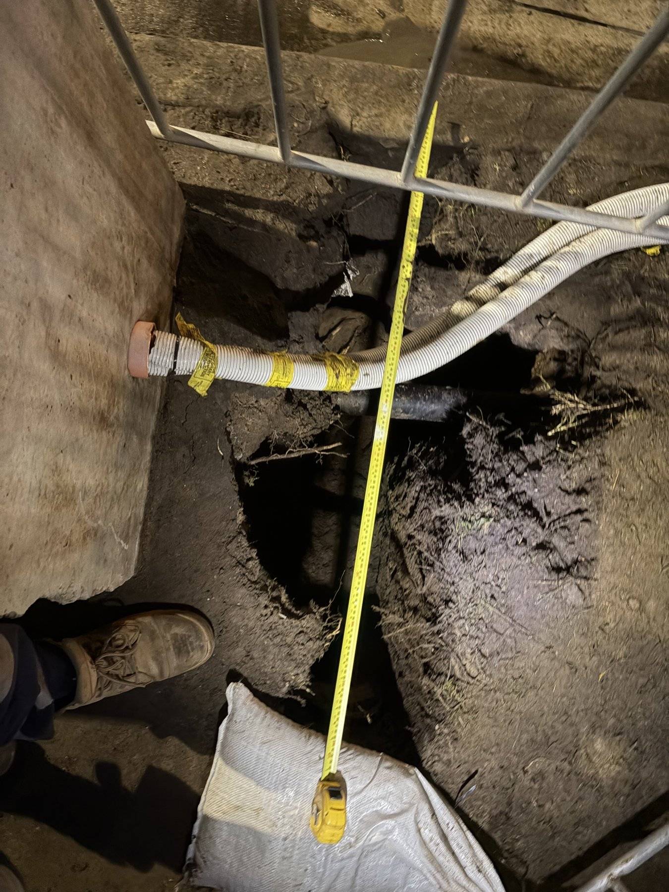 Exposed services in an open excavation with a tape measure