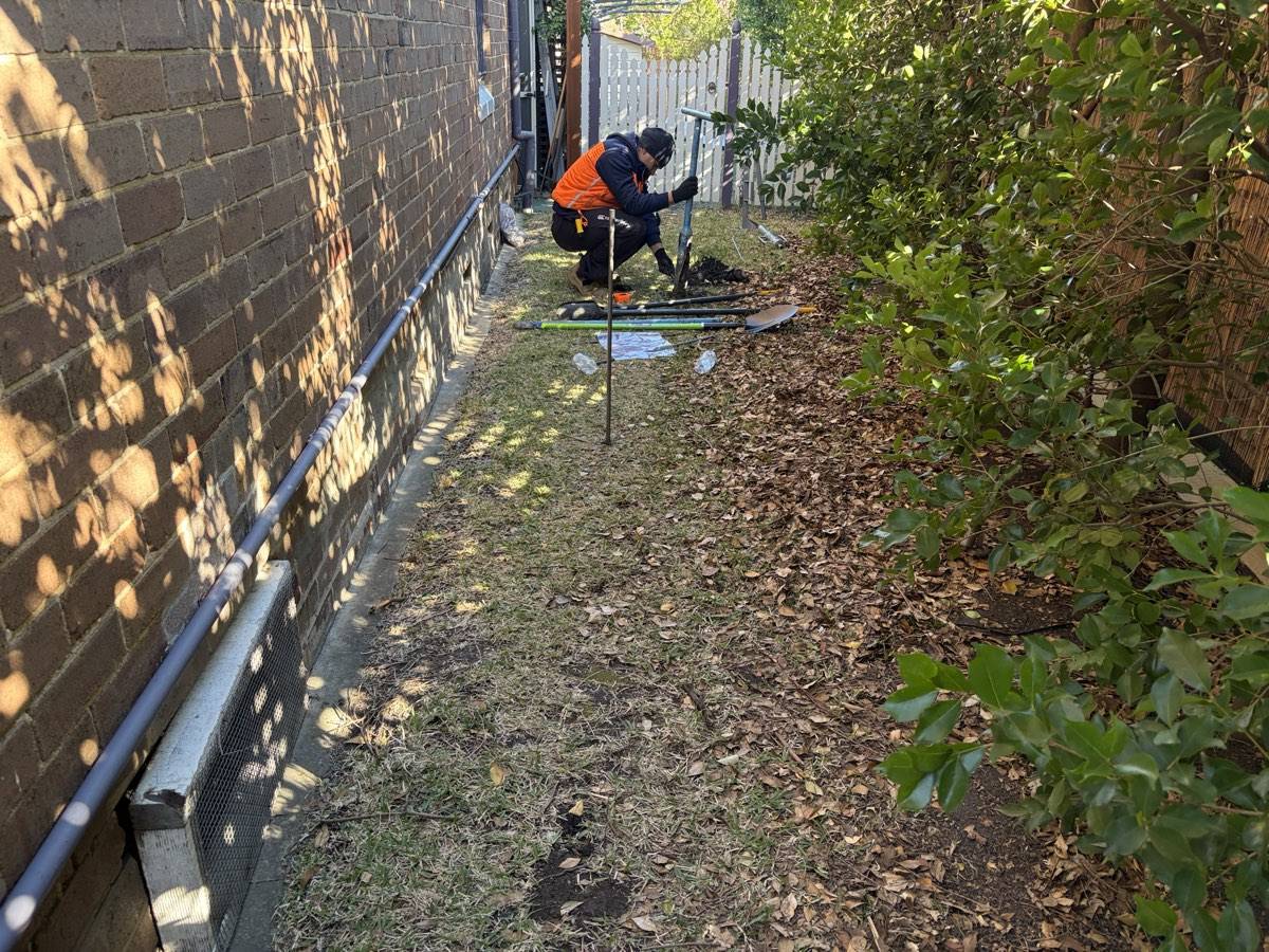 Hand auger boreholing down a narrow side path beside a Sydney home