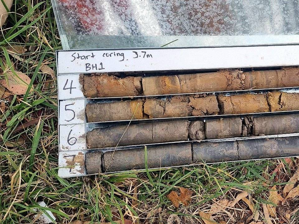 Rock core laid out in a core tray at BH1, coring from 3.7 metres, weathered runs over grey shale, labelled run by run