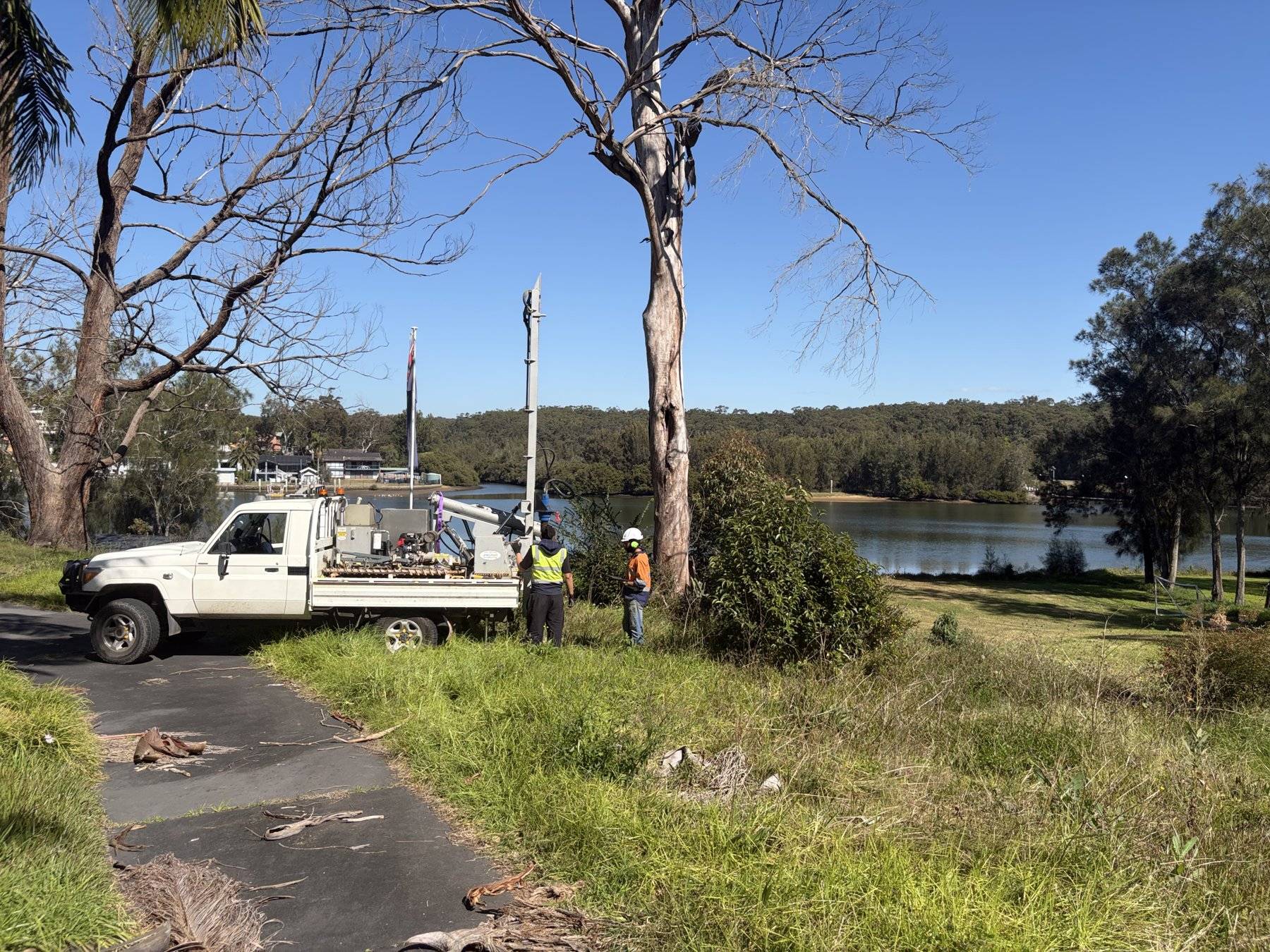 Rig with mast raised working a borehole above the river