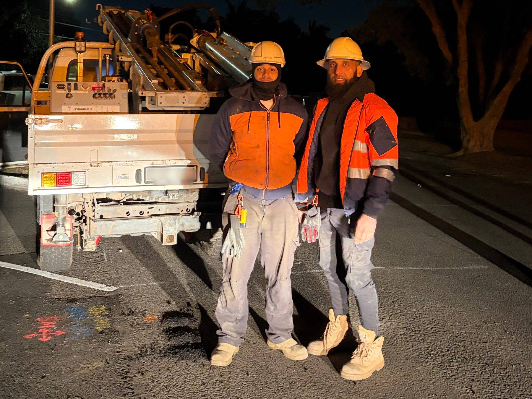 The Principal and the crew in hard hats and hi-vis beside the ute-mounted drill rig on a Concord street at the end of a night shift