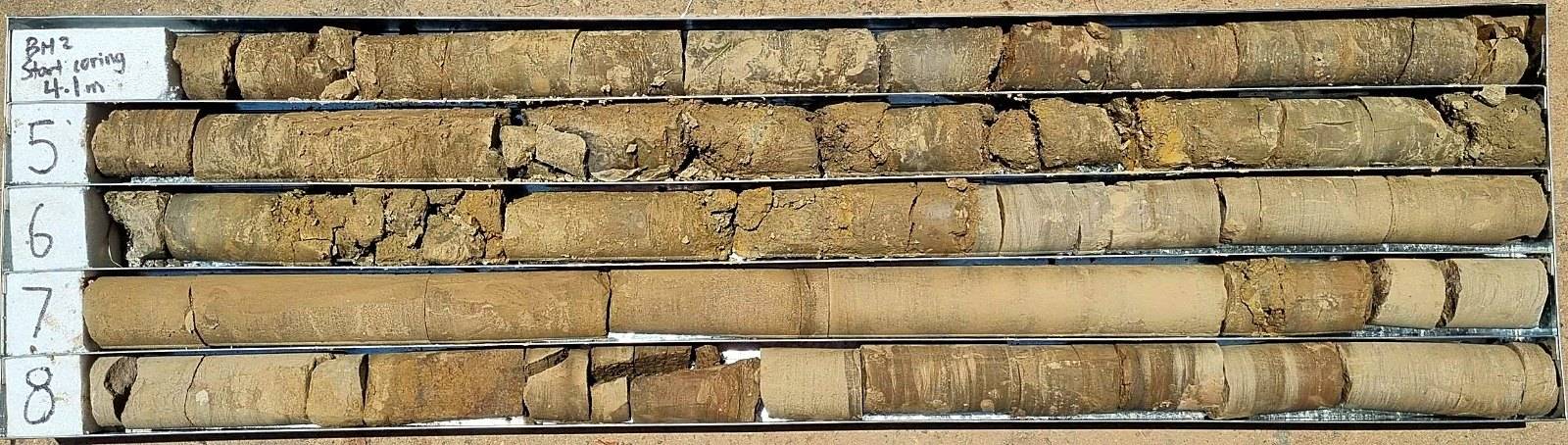 Four runs of rock core in a tray at BH2, coring from 4.1 metres, laid out and labelled for logging